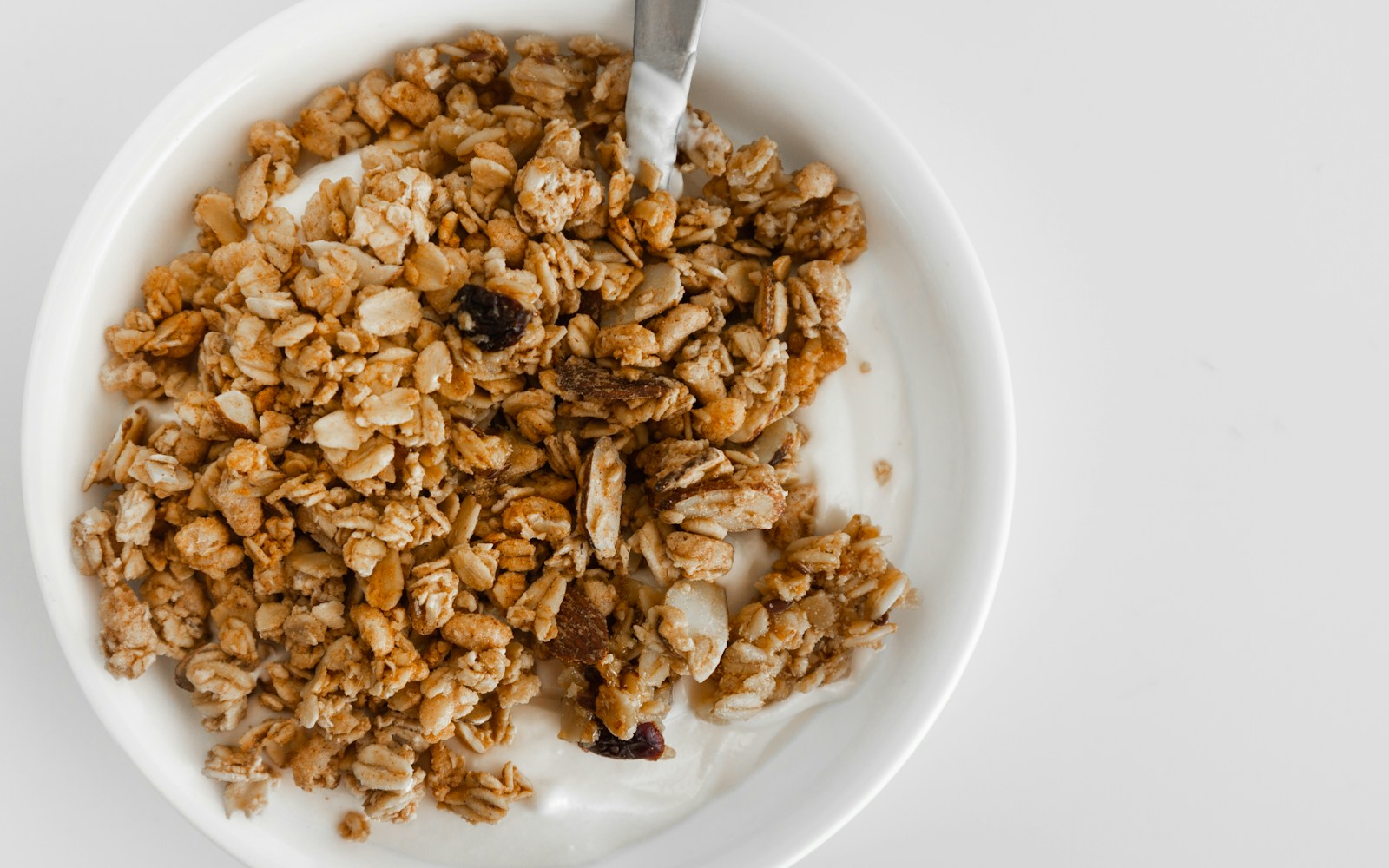 Golden maple granola clusters with pecans on a parchment-lined tray
